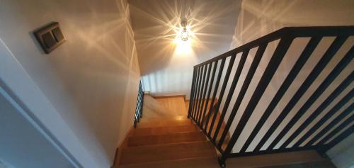 a hallway with a staircase with a light on the ceiling at Domek przy Kasztanowej in Szczyrk