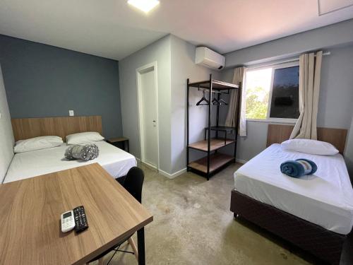 een hotelkamer met 2 bedden en een tafel bij WS SUÍTES HOTEL in Três Passos