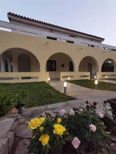 Un edificio con un mazzo di fiori davanti di Villa Bianca a Chia