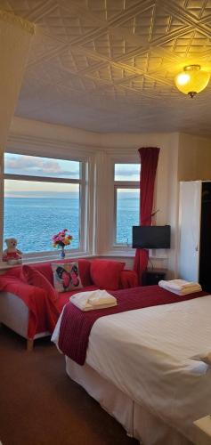 a bedroom with a large bed with a view of the ocean at Ash Hotel B&B in Exmouth