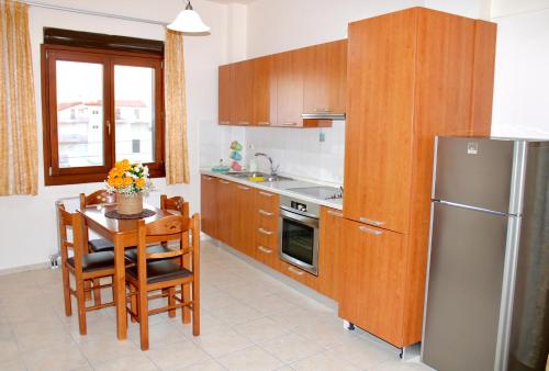 a kitchen with a refrigerator, stove, microwave and a table at George Airport Apartments in Heraklio