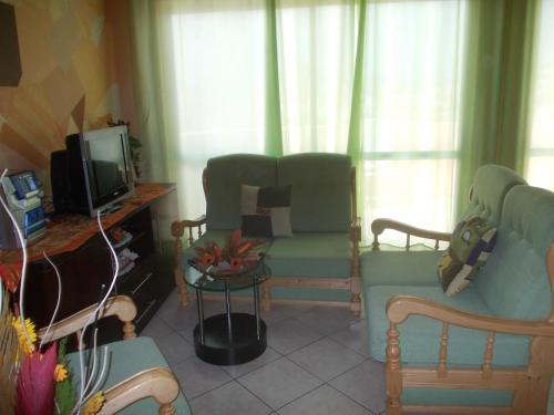 a living room with a couch and a tv at Casa Comba in Mindelo