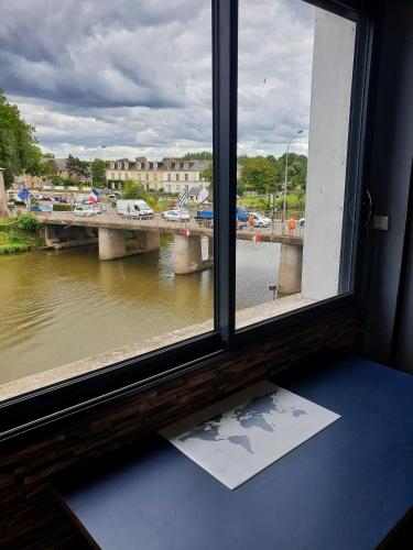 een raam met uitzicht op een rivier en een brug bij Appartement bord de vilaine, proche centre et gare in Redon