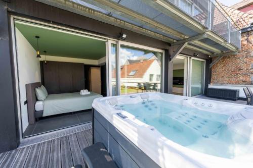 eine große Badewanne auf einer Terrasse mit einem Schlafzimmer in der Unterkunft SPA & Garden - Luxury Private Apart' Mons Center in Mons