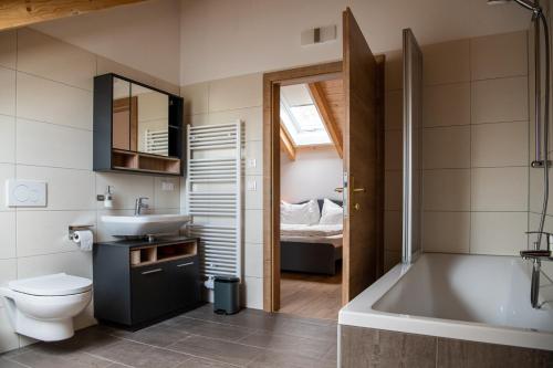 a bathroom with a tub and a sink and a toilet at Ganzes Haus mit viel Platz für Familie und Freunde in Klagenfurt