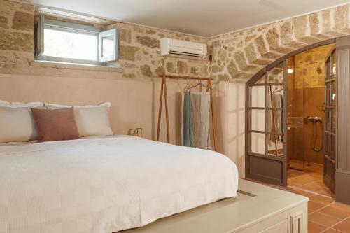 um quarto com uma cama branca e uma janela em Saray Monumental Luxury Villa Medieval Town, Rhodes em Rodes