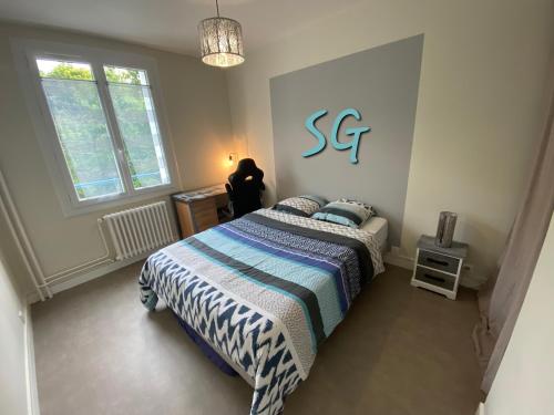 - une chambre dotée d'un lit avec un panneau bleu sur le mur dans l'établissement Superbe logement - 2 chambres - en centre-ville avec parking, à Troyes