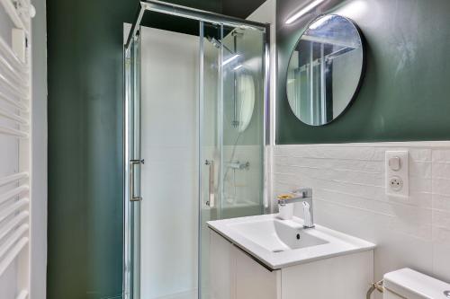 uma casa de banho com um lavatório e um chuveiro com um espelho. em VILLA VERDE #Hypercentre #Charente #Parking em Cognac