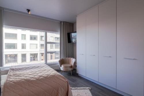 a bedroom with a bed and a large window at Ocean Breeze Luxury Apartment in Reykjavík