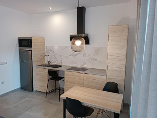 a kitchen with a counter and a table with chairs at APARTAMENTOS LOS GUINDOS in Málaga