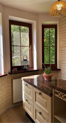 a kitchen with two windows and a counter top at Uroczy dom Wszebory in Wszebory