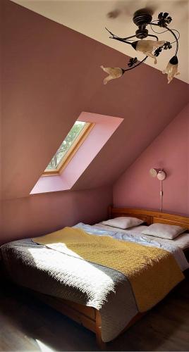 a bedroom with a bed and a ceiling with a window at Uroczy dom Wszebory 