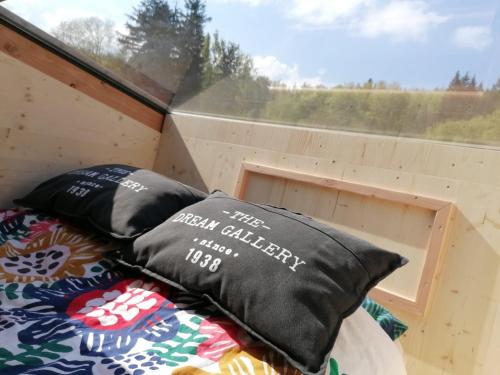 a bed in a tiny house with a window at Monchateau étoilé, hébergement insolite avec Spa in Merlas