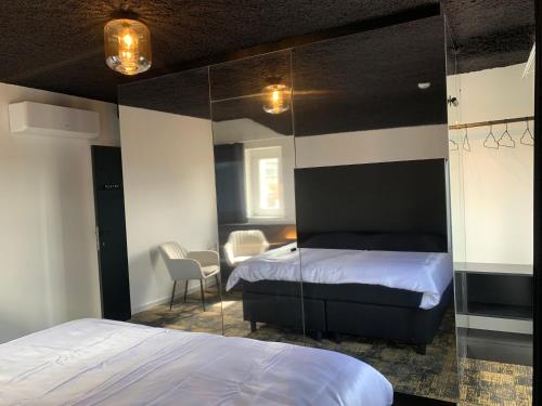 a bedroom with a bed and a mirror at Bed & Breakfast Maison Noire Westende-bad incl parking & ontbijt in Middelkerke