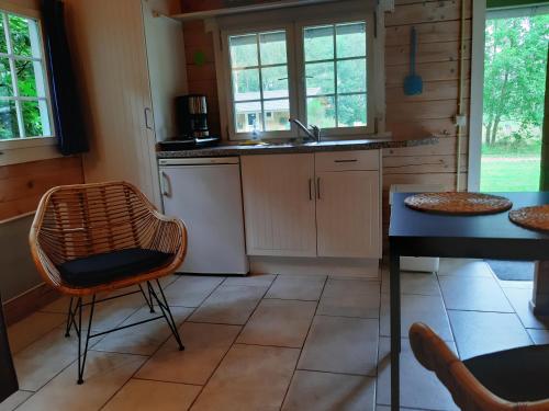 uma cozinha com um lavatório, uma mesa e cadeiras em reiger em Appelscha