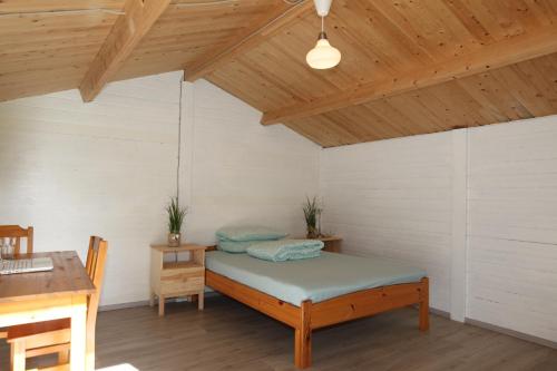 Bett in einem Zimmer mit Holzdecke in der Unterkunft Ostseecamp Lübecker Bucht Wanderhütte in Scharbeutz