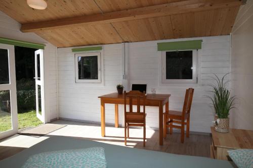 ein Zimmer mit einem Tisch und Stühlen in einer Hütte in der Unterkunft Ostseecamp Lübecker Bucht Wanderhütte in Scharbeutz