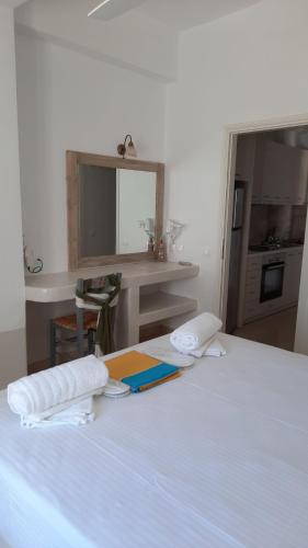 a bedroom with a white bed with towels on it at Flora Apartments in Drios