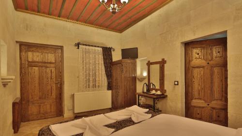 a bedroom with a bed and a chandelier at Cappadocia Cave Land Hotel in Goreme