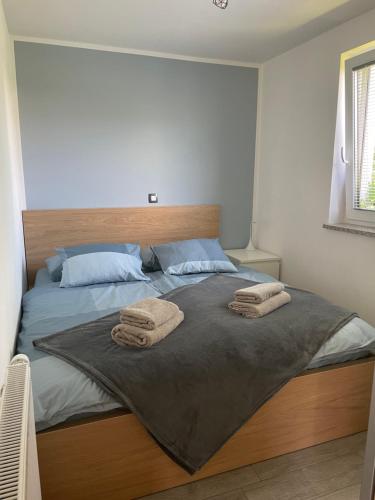 a bedroom with a large bed with two towels on it at Apartments Kolačko in Bohinj