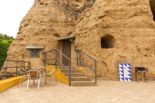 un edificio con escaleras, mesa y sillas en Cuevas de las Bardenas, en Valtierra