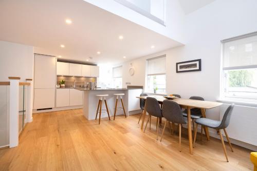 a kitchen and dining room with a table and chairs at Edinburgh Modern 3-Storey 3-Bedroom City Apartment in Edinburgh