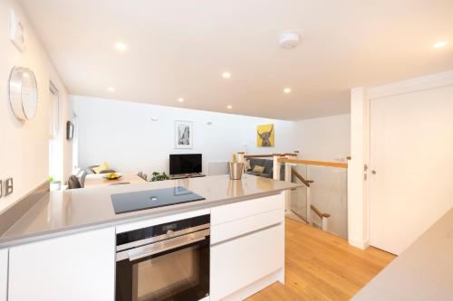 a kitchen with white cabinets and a counter top at Edinburgh Modern 3-Storey 3-Bedroom City Apartment in Edinburgh