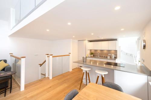 a kitchen with white cabinets and a table and chairs at Edinburgh Modern 3-Storey 3-Bedroom City Apartment in Edinburgh