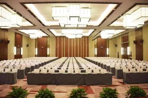 a large banquet hall with white tables and chairs at Howard Johnson Neodalle Resort Zhangjiajie in Zhangjiajie