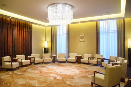 a large room with chairs and tables and a chandelier at Howard Johnson Neodalle Resort Zhangjiajie in Zhangjiajie