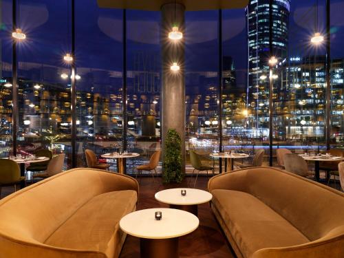 a restaurant with tables and chairs and a view of the city at Crowne Plaza - Warsaw - The HUB by IHG in Warsaw