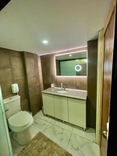 a bathroom with a toilet and a sink and a mirror at Hotel Finca San Nicolas in San Salvador