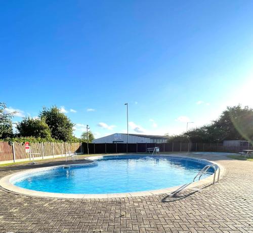 a small swimming pool in the middle of a brick road at Stonesthrow 184 Broadside Chalet Park Stalham in Stalham