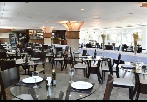 une salle à manger avec des tables et des chaises dans un restaurant dans l'établissement Gran Lençóis Flat Residence, à Barreirinhas