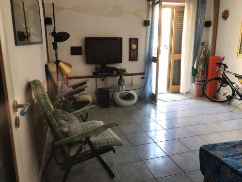 a living room with a chair and a television at La Casetta Bianca Vicino Mare in Vibo Valentia Marina