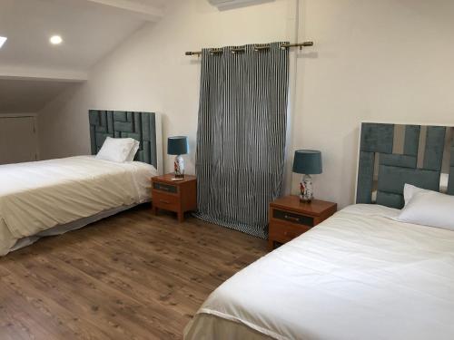 - une chambre avec 2 lits et 2 tables de nuit avec des lampes dans l'établissement Villa Populo, à Ponta Delgada