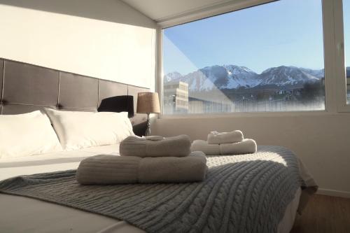 a bedroom with a bed with towels on it at Ona Shelter in Ushuaia