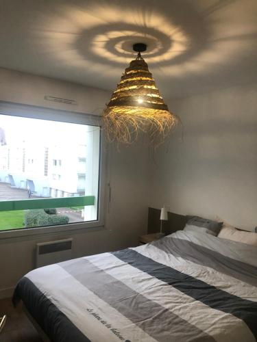 una camera da letto con un letto e un lampadario di Les Bains de Wimereux a Wimereux