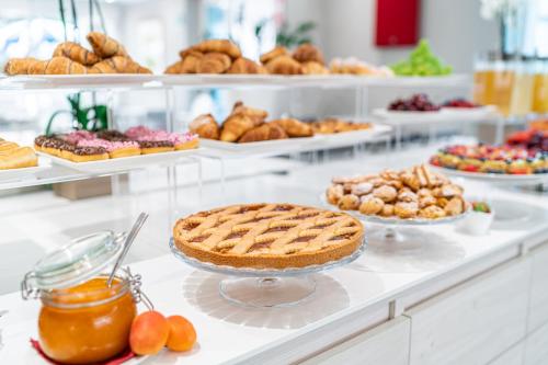 Una línea de buffet con tartas, pasteles y otros postres. en Princess Aparthotel, en Bibione