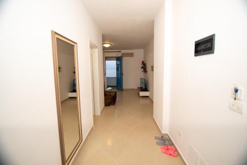 - un couloir avec un miroir et quelques chaussures au sol dans l'établissement BEACHSITE, à Vlorë
