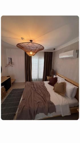a bedroom with a large bed and a chandelier at LAGOM HOTEL in Seferihisar