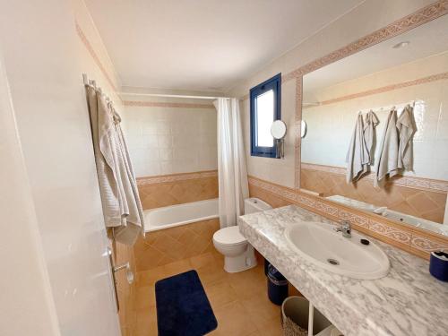 a bathroom with a sink and a toilet and a mirror at Apartamento Vilem & Piscina, Wi-Fi in Costa Calma