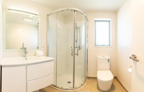 a bathroom with a shower and a toilet and a sink at 18 Jimmys Apartment in Lake Tekapo