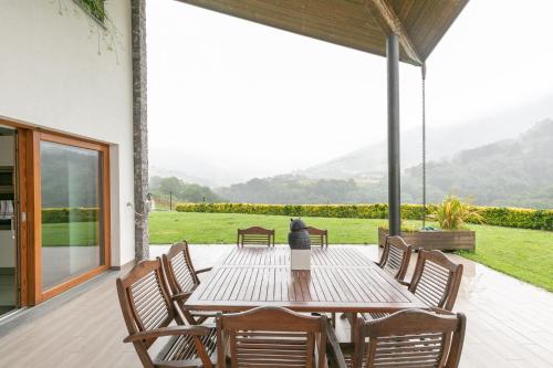 a wooden table and chairs on a patio at Belabieta - baskeyrentals in Berrobi
