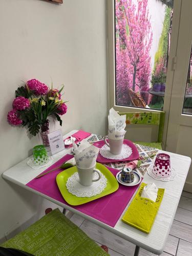 een tafel met twee kopjes en borden en bloemen erop bij B&B 091 in Palermo