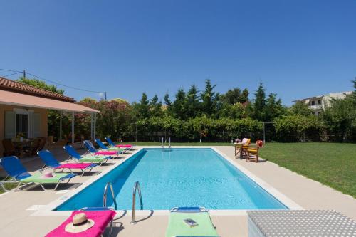 a swimming pool with lounge chairs and a swimming pool at Villa Stafili by Villa Plus in Litherés