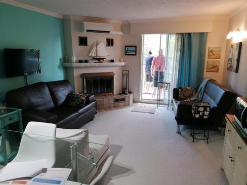 a living room with leather furniture and a fireplace at Superbe condo bord de l'eau à Magog in Magog-Orford