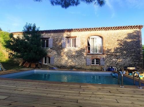 a house with a swimming pool in front of a building at Le Wigwam du Fassac in Saint-Julien-du-Puy