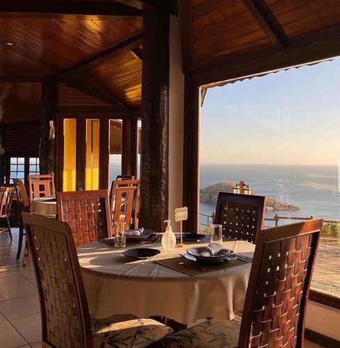 a table in a restaurant with a view of the ocean at Sentinelas do Mar in Arraial do Cabo
