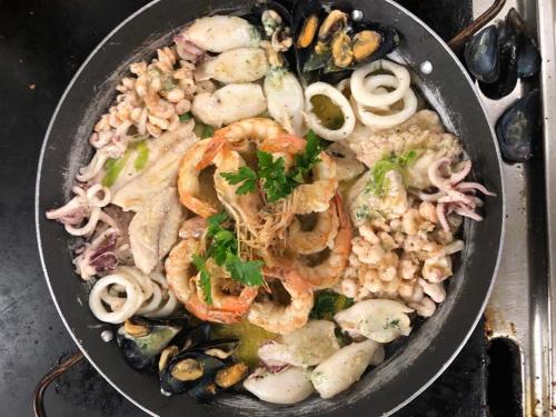 a pan of food with shrimp and other vegetables at Hotel Adriatik 2 in Durrës